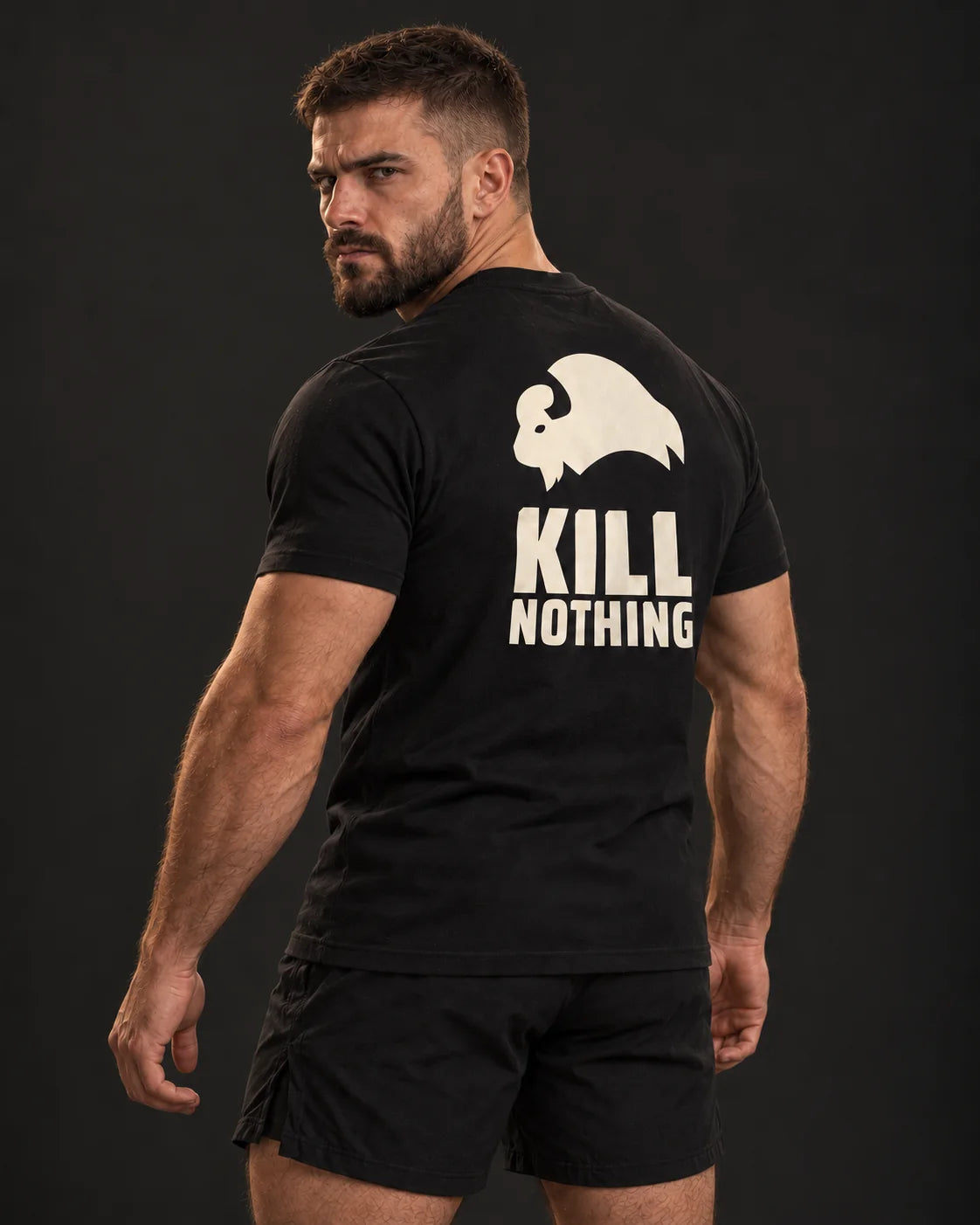 Kill Nothing Club - Slim Tee, black, worn by an athlete, studio photo (AI-generated image)