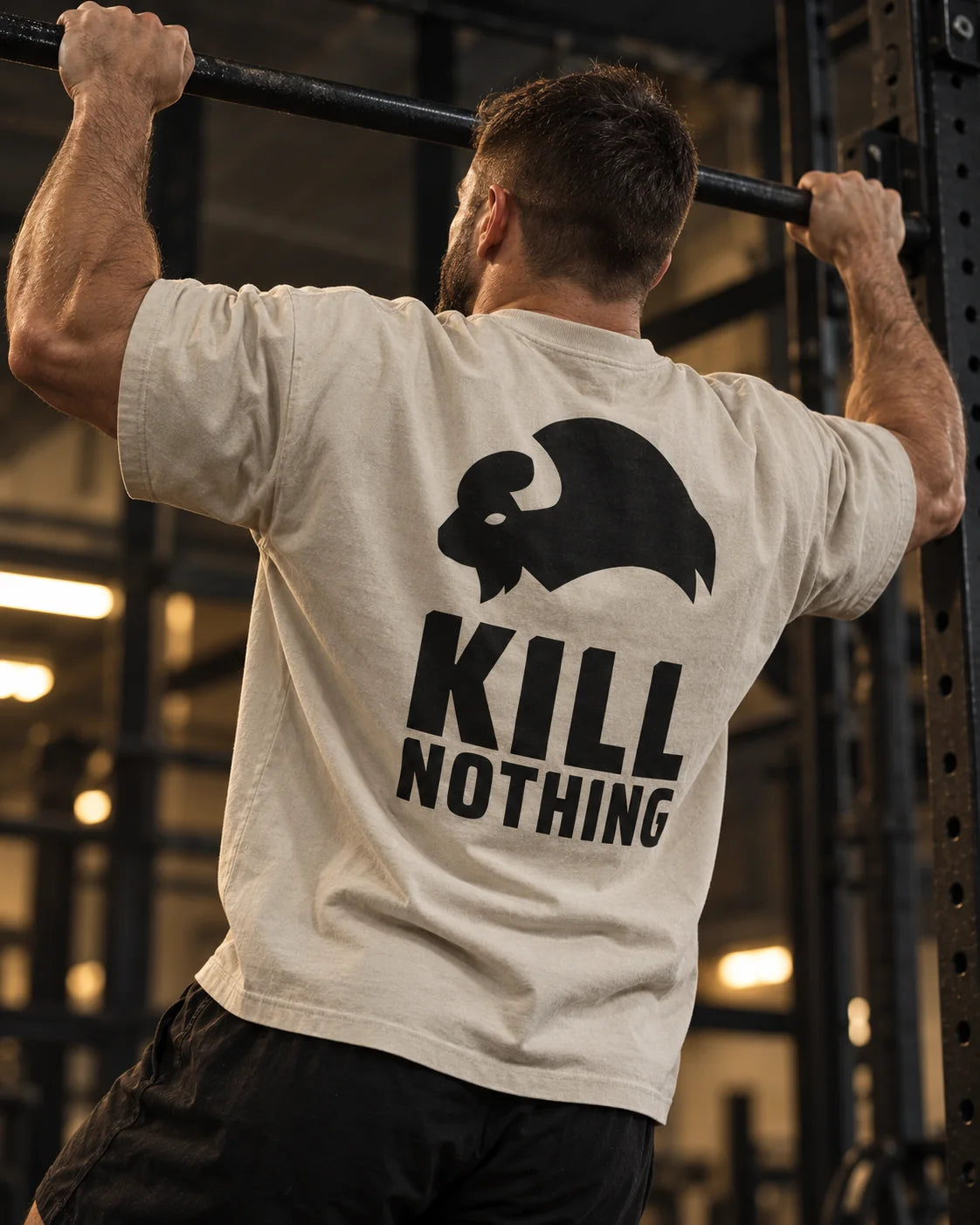 Kill Nothing Club - Oversized Tee, stone, worn by an athlete in the gym (AI-generated image)