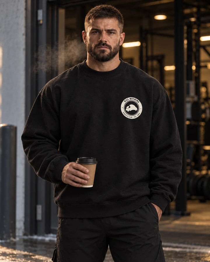 Club Crest - Crewneck Sweatshirt, black, worn by an athlete in the gym (AI-generated image)